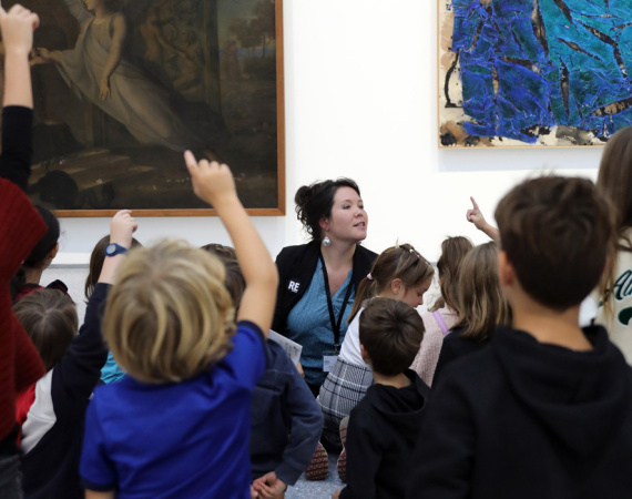 Médiatrice culturelle s'exprimant devant des visiteurs, dans une exposition