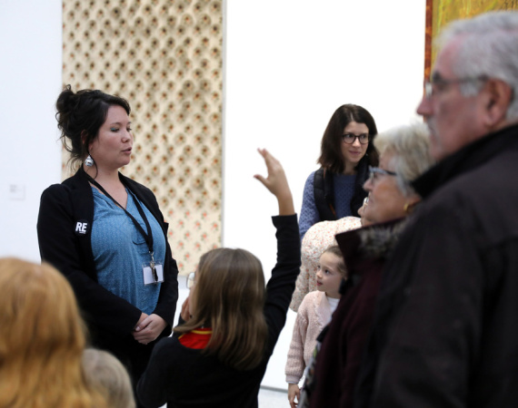 Médiatrice culturelle s'exprimant devant des visiteurs, dans une exposition