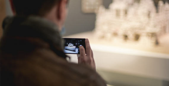 Visiteur prenant en photographie une œuvre
