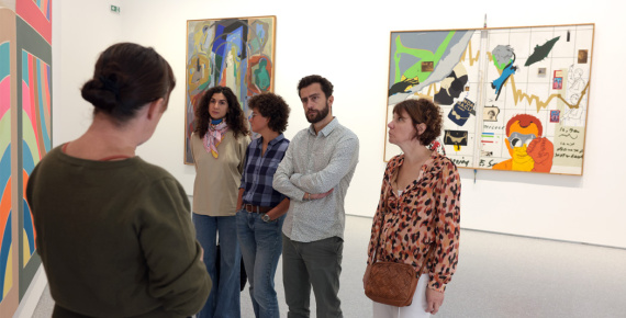 Médiatrice culturelle s'exprimant devant des visiteurs dans une exposition