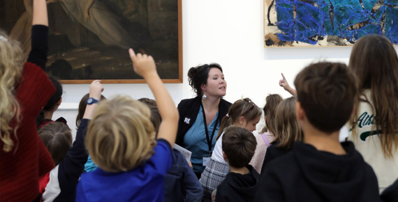 Médiatrice culturelle s'exprimant devant des visiteurs, dans une exposition