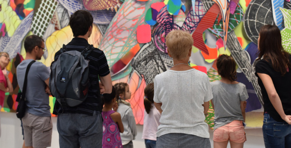 Visiteurs se tenant devant un tableau