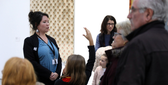 Médiatrice culturelle s'exprimant devant des visiteurs, dans une exposition