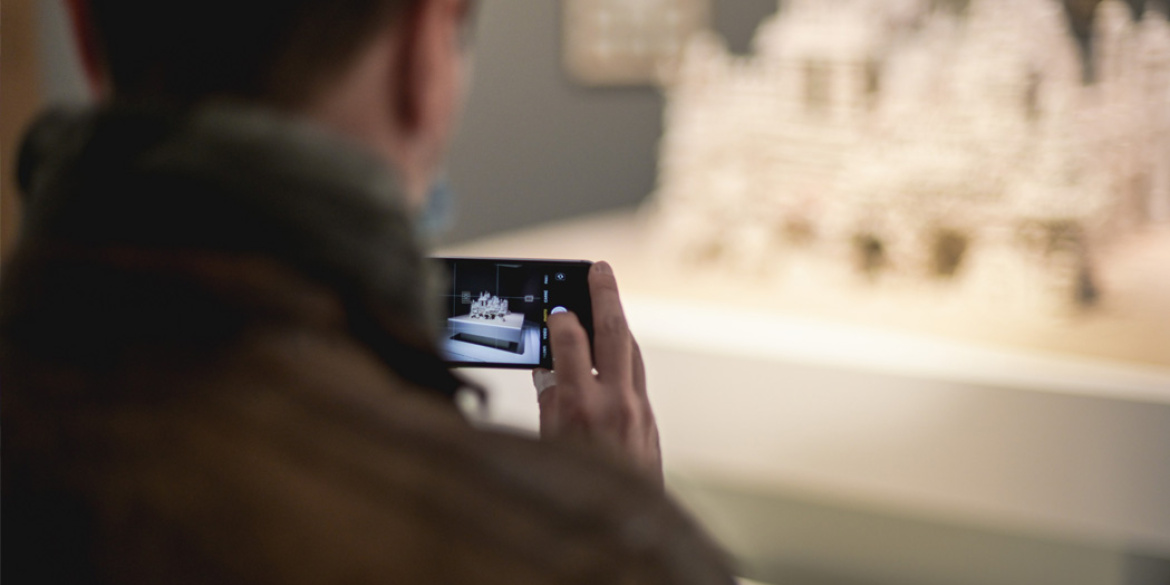 Visiteur prenant en photographie une œuvre