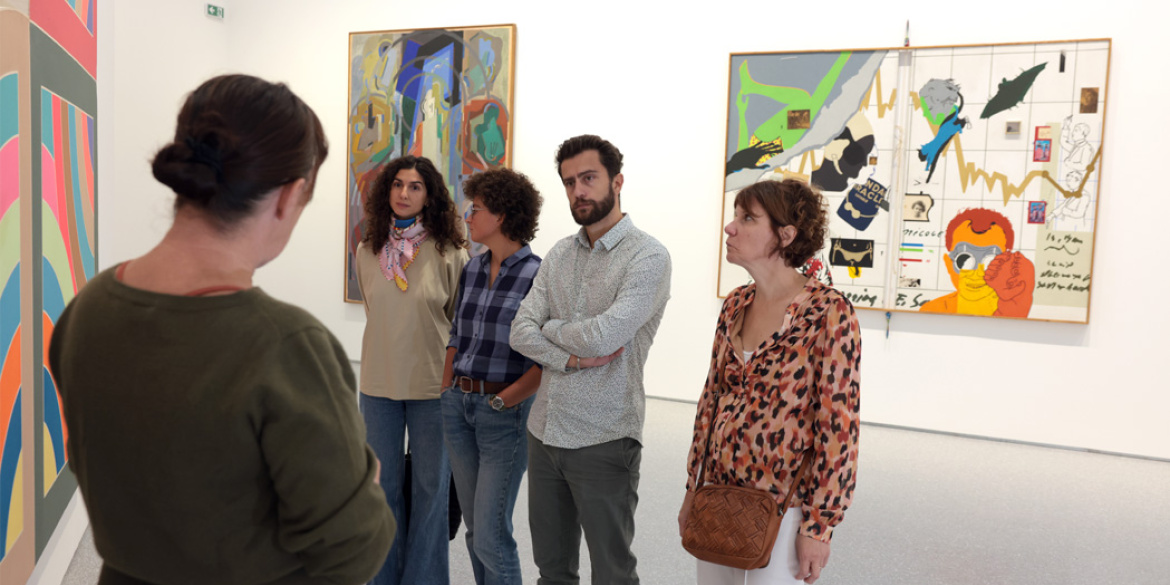 Visiteurs écoutant une médiatrice dans l'exposition Hors Format - Collections en chantier