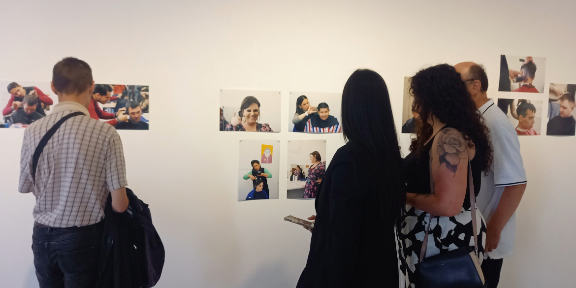 Des personnes se tiennent devant une exposition de photographies.