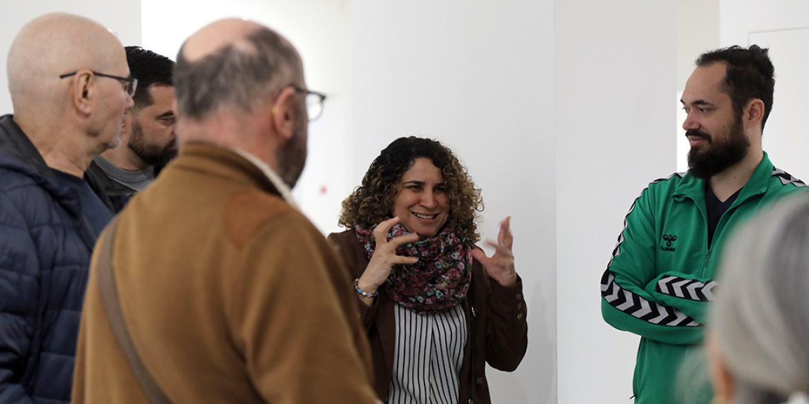 Visiteurs dans une salle d'exposition parlant en LSF