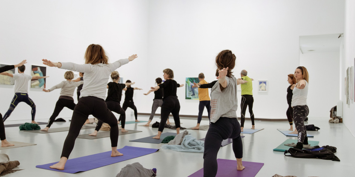 Visiteurs faisant du yoga dans une salle d'exposition