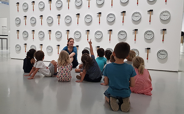 Groupe d'enfants devant "Local Time", de Jean-Luc Vilmouth, exposition des collections "Vingt-quatre heures de la vie d'une femme" avec Betty